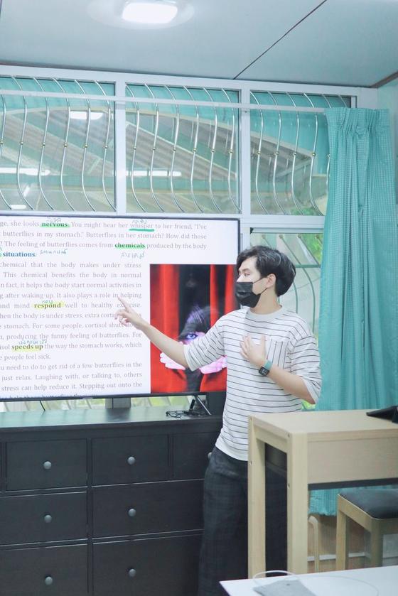 ครูชี้อธิบายคำศัพท์ในบทอ่านบนจอทีวี